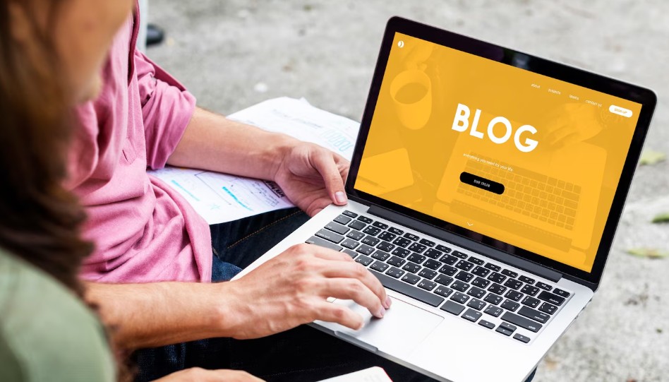 Dve osobe pregledaju blog na laptopu dok zajedno rade na sadržaju sajta